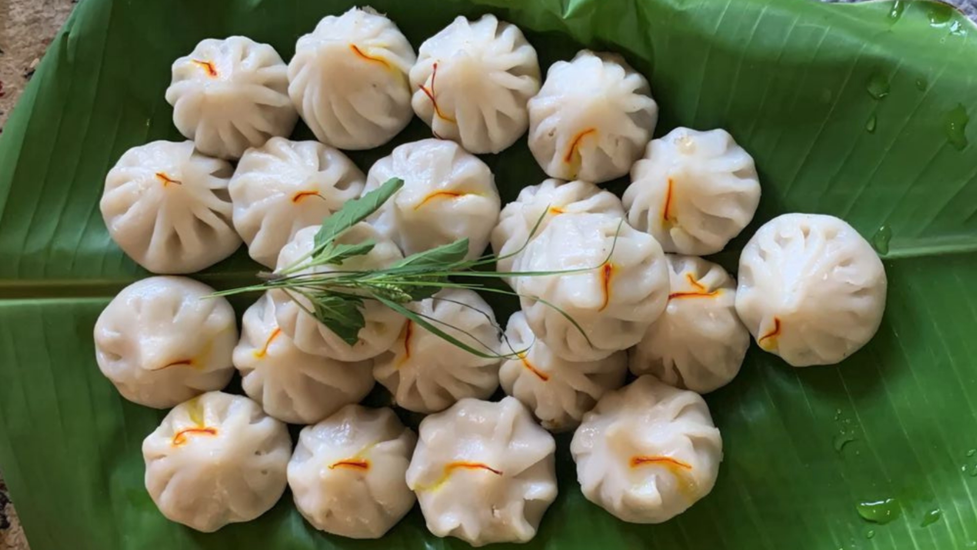 Steamed ukadiche modak arranged on a banana leaf