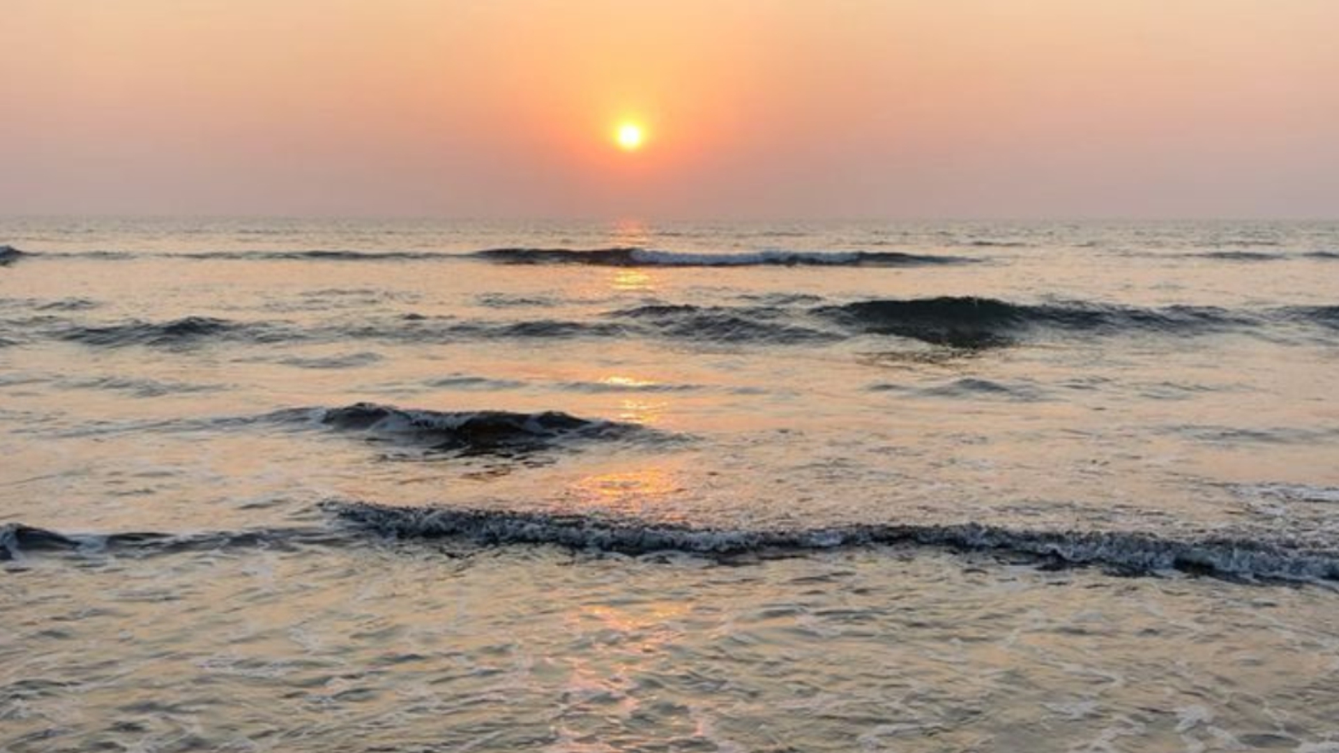 Sunset over calm sea waves on the Kokan coast