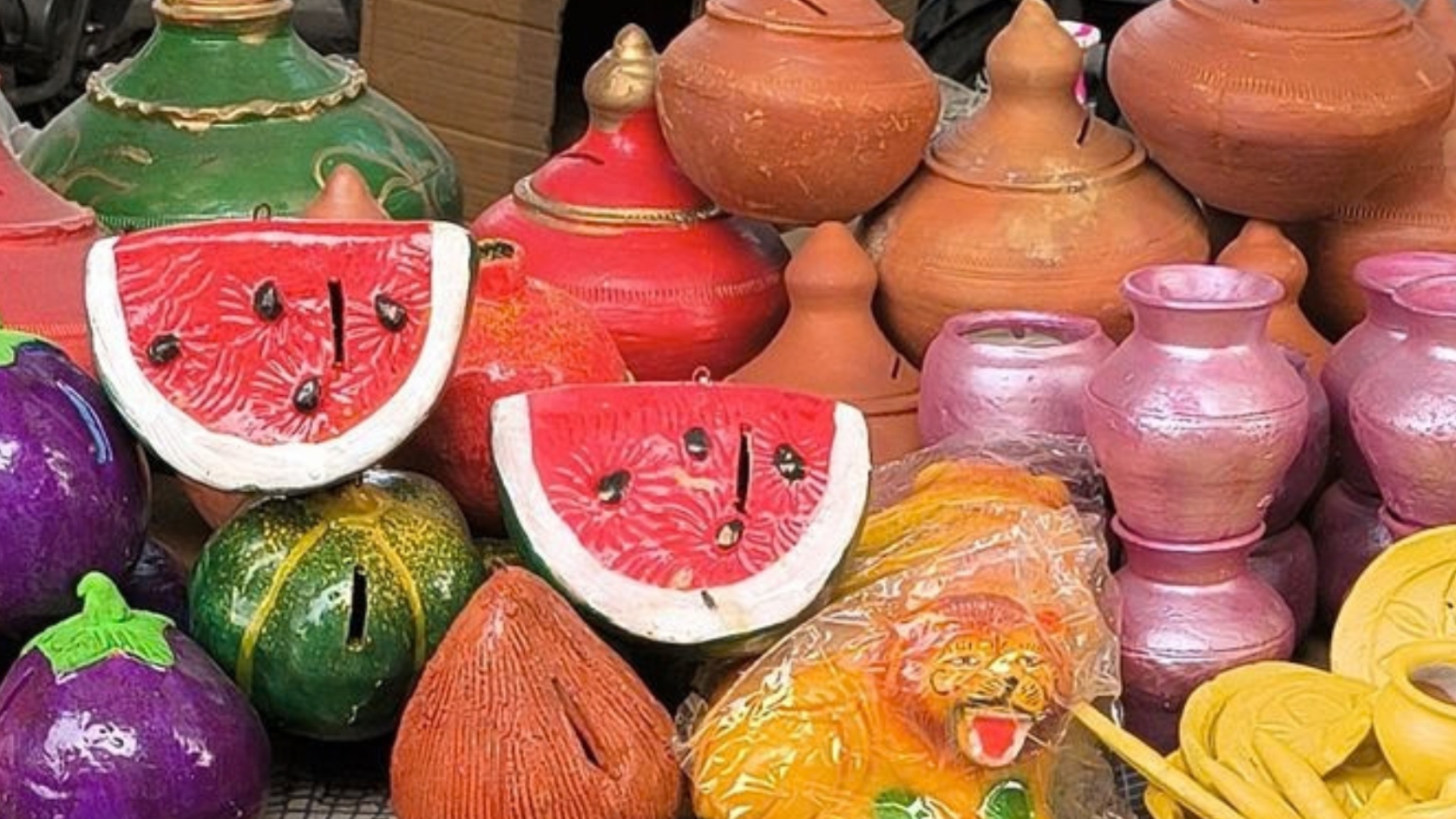 Painted terracotta pots and pitchers stacked at a local market