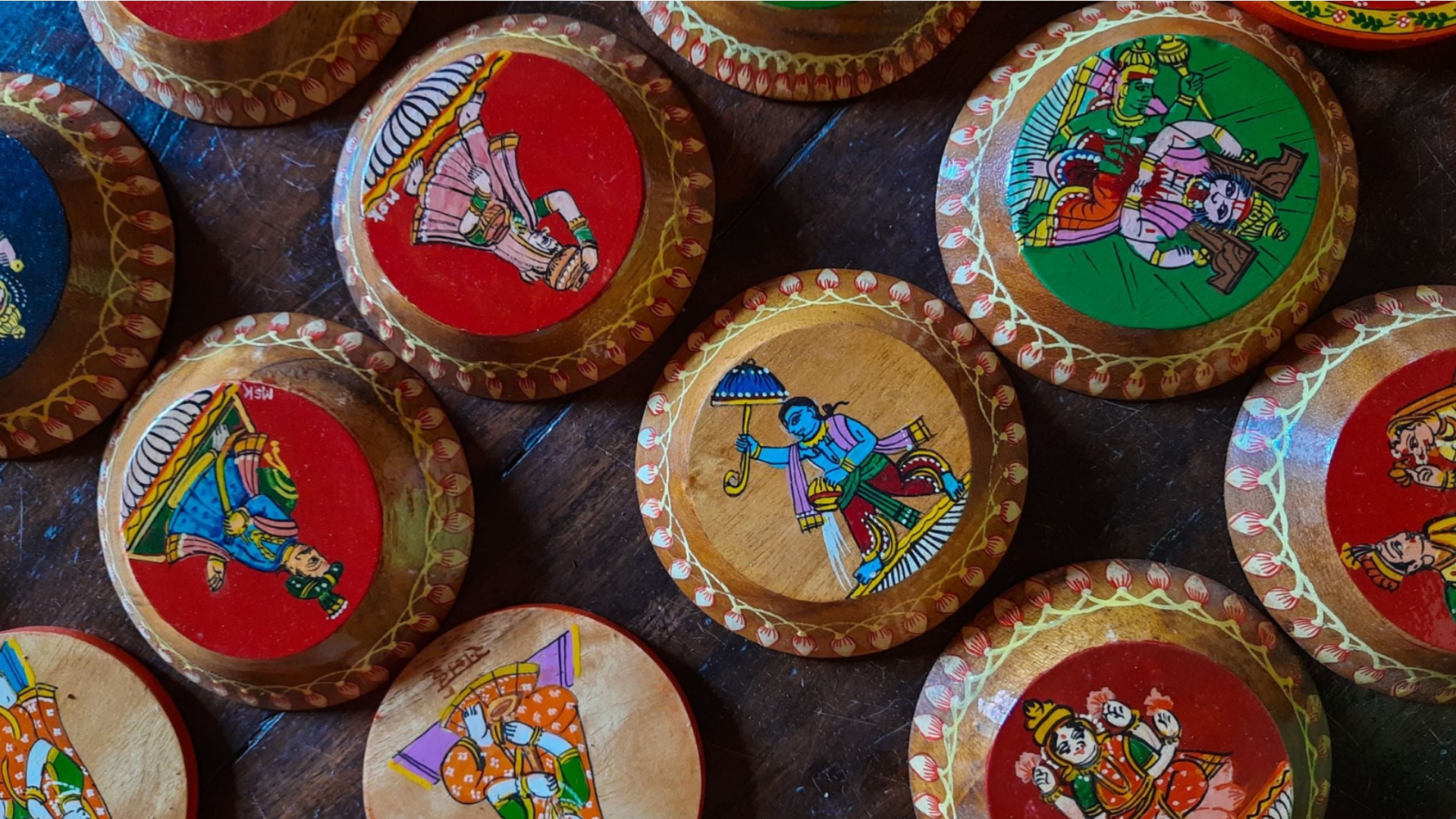 Hand-painted decorative wooden plates on display at a craft market